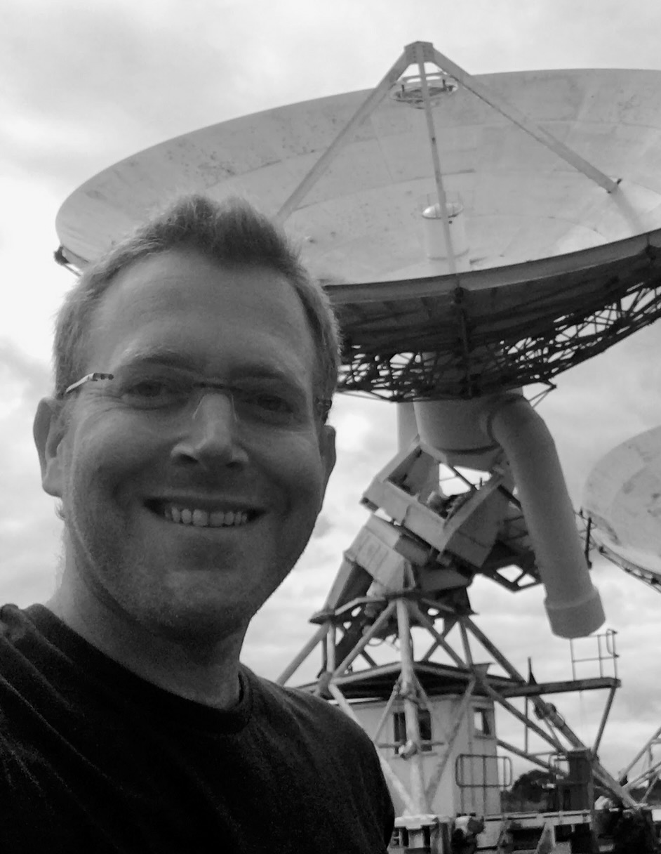 Assaf Horesh in front of a radio telescope dish